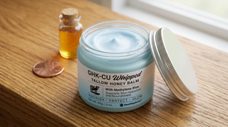 GHK-Cu copper peptide tallow balm in blue jar on oak surface with honey and copper