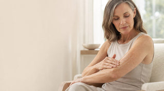 Woman in her fifties smoothing lotion along her forearm, showing crepey skin on the arms