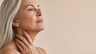 Woman around sixty touching her jawline and neck, the area where sagging jowls form after 50