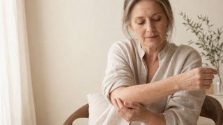 Woman in her fifties examining dry flaking eczema-prone skin on her forearm and inner elbow